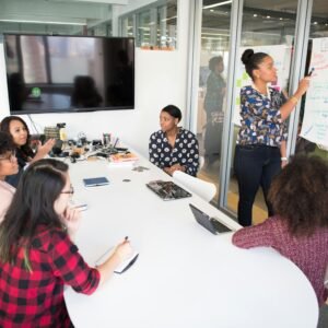 A multicultural office team engages in a collaborative brainstorming session around a conference table.