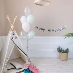Cozy indoor birthday setup with teepee, balloons, and presents, perfect for kids' celebrations.