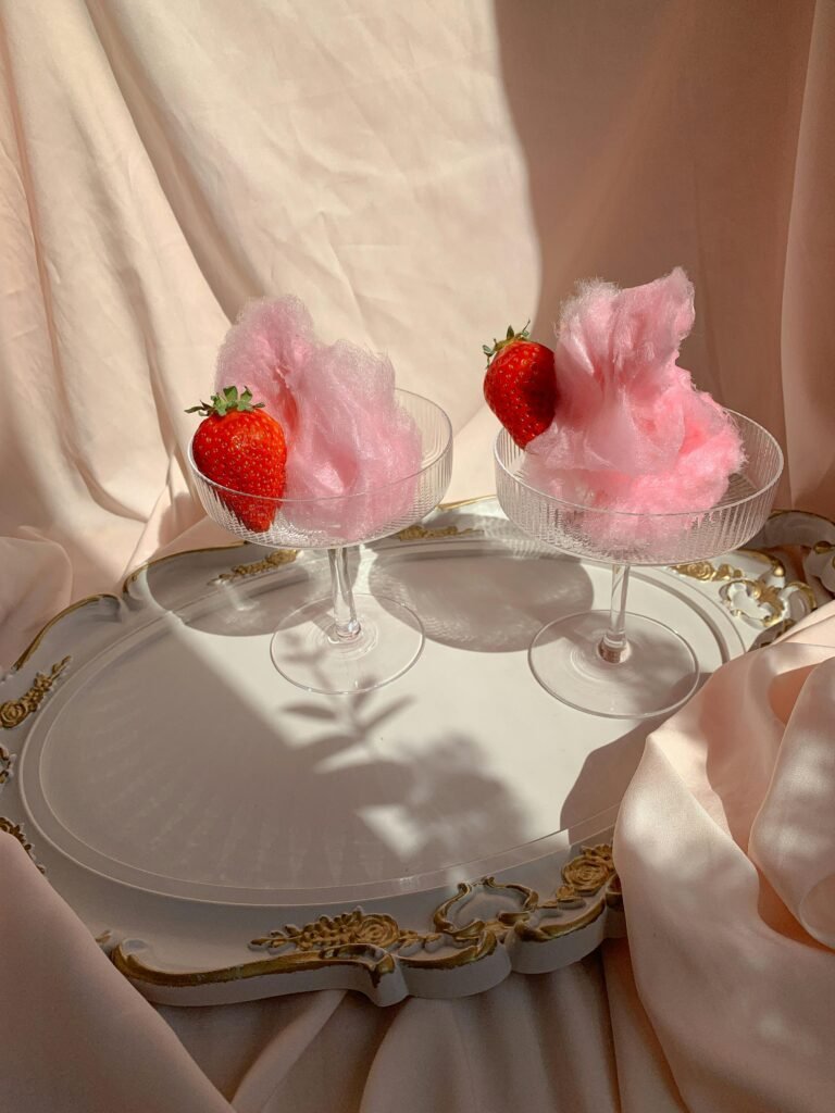 pexels photo 8105067 8105067 Two glass cups with pink cotton candy and strawberries on an ornate tray, creating a chic dessert presentation.